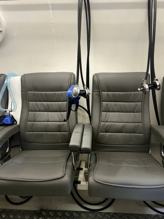 Poltronas reclináveis da câmara coletiva com máscaras de oxigênio