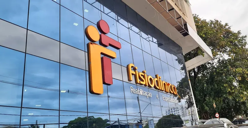 Detalhe da fachada de vidro com o logotipo da Fisioclínica